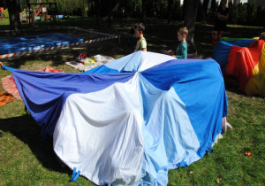 chusta animacyjna w kolorach zimowych okrywa dzieci tworząc okrągły namiot